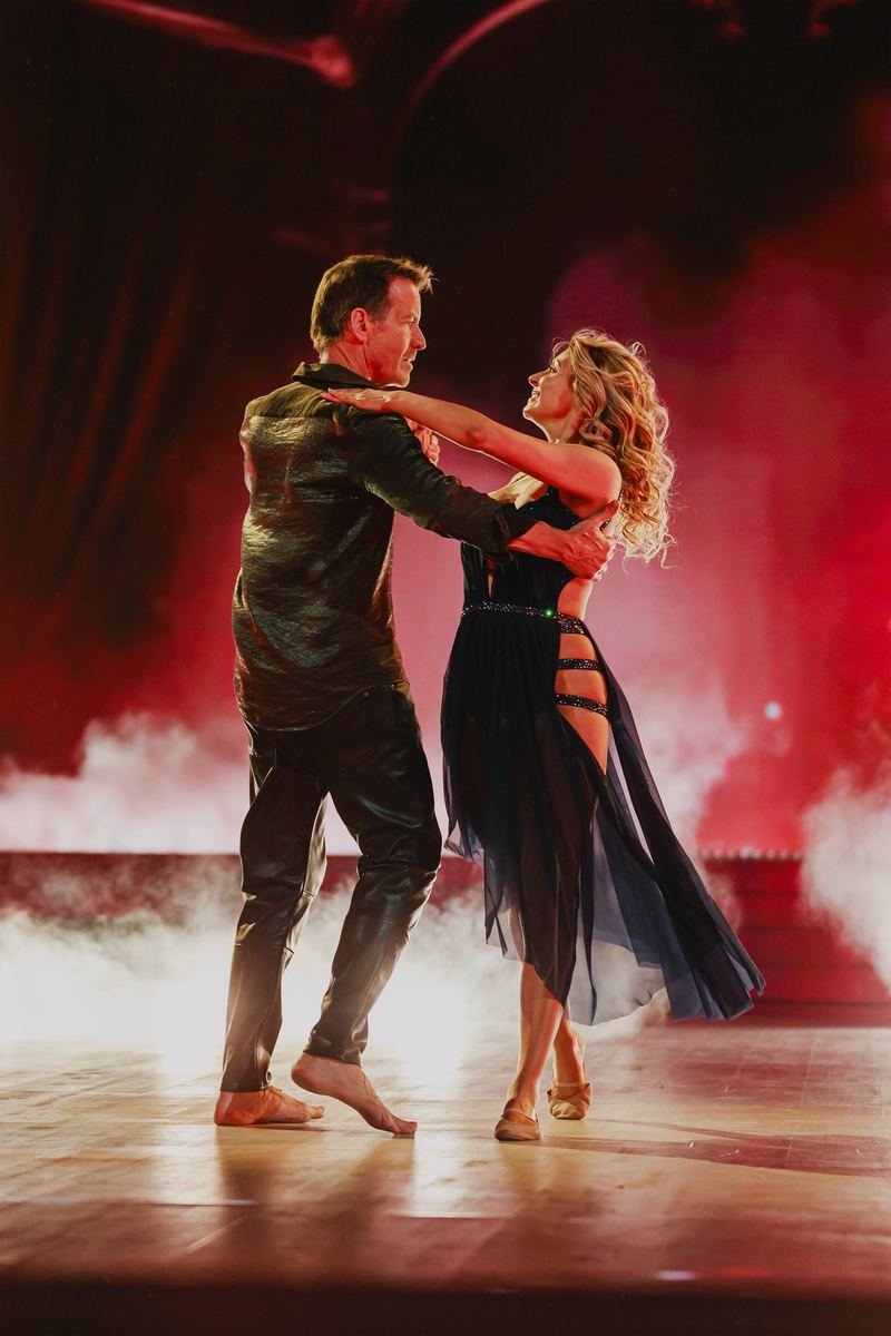 Couple de danseurs en pleine chorégraphie sur fond de fumée rouge