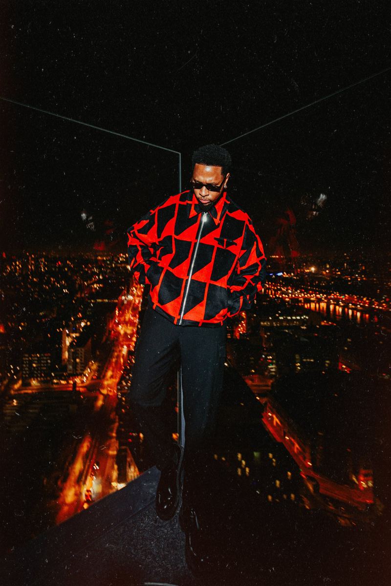 Portrait sur un rooftop, veste graphique et ville illuminée en contrebas