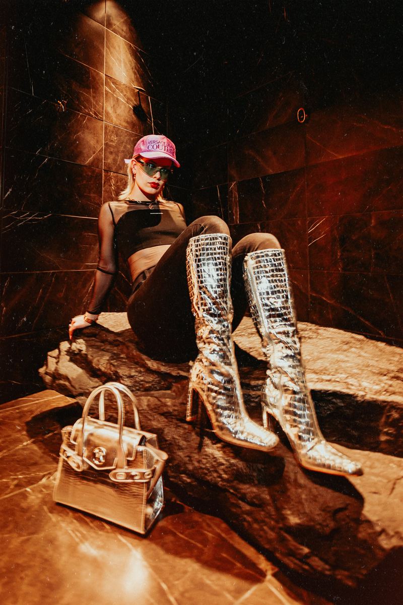 Séance lifestyle : bottes hautes et sac assortis sur un décor minéral