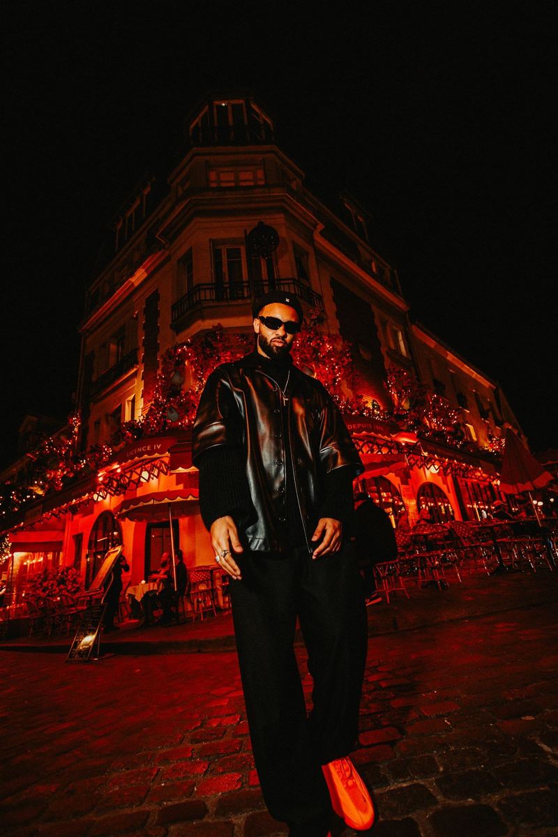 Portrait nocturne devant une brasserie parisienne baignée de rouge