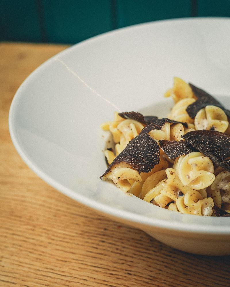Gros plan sur des pâtes à la crème et copeaux de truffe