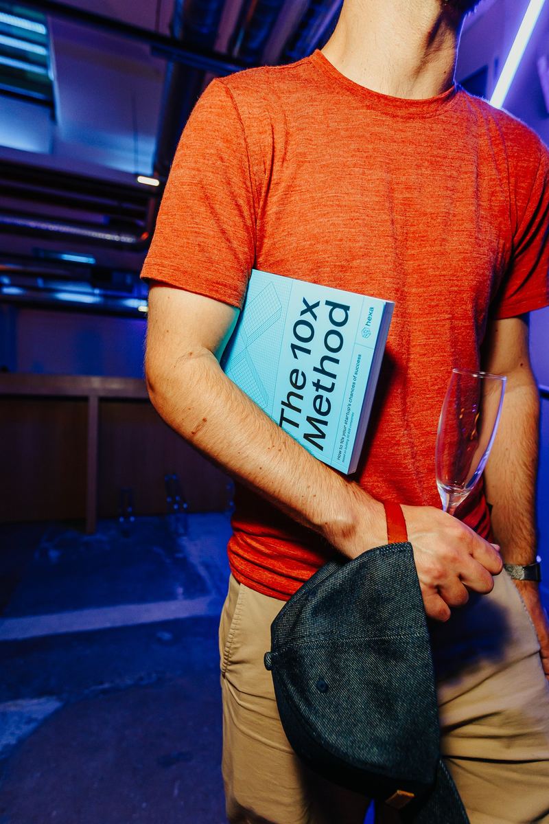 Un exemplaire du livre et une coupe à la main pendant le cocktail