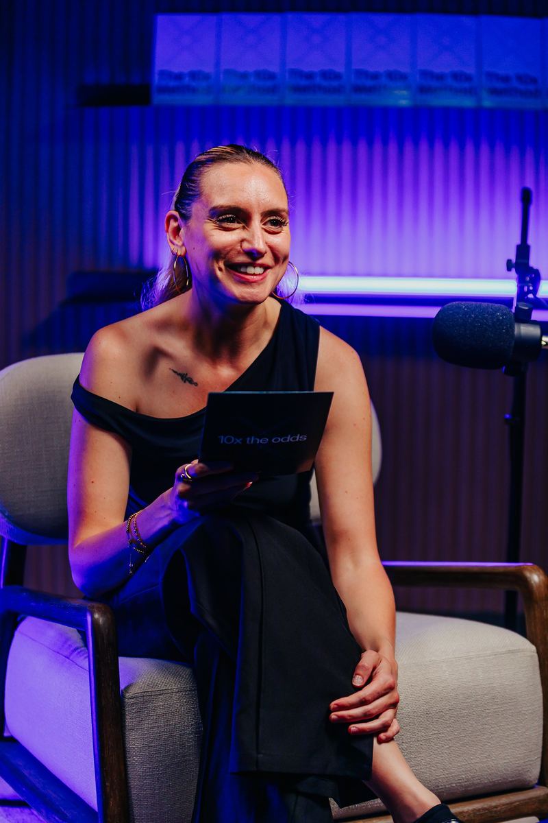 Intervenante rit sur le plateau du podcast, micro suspendu au-dessus d’elle