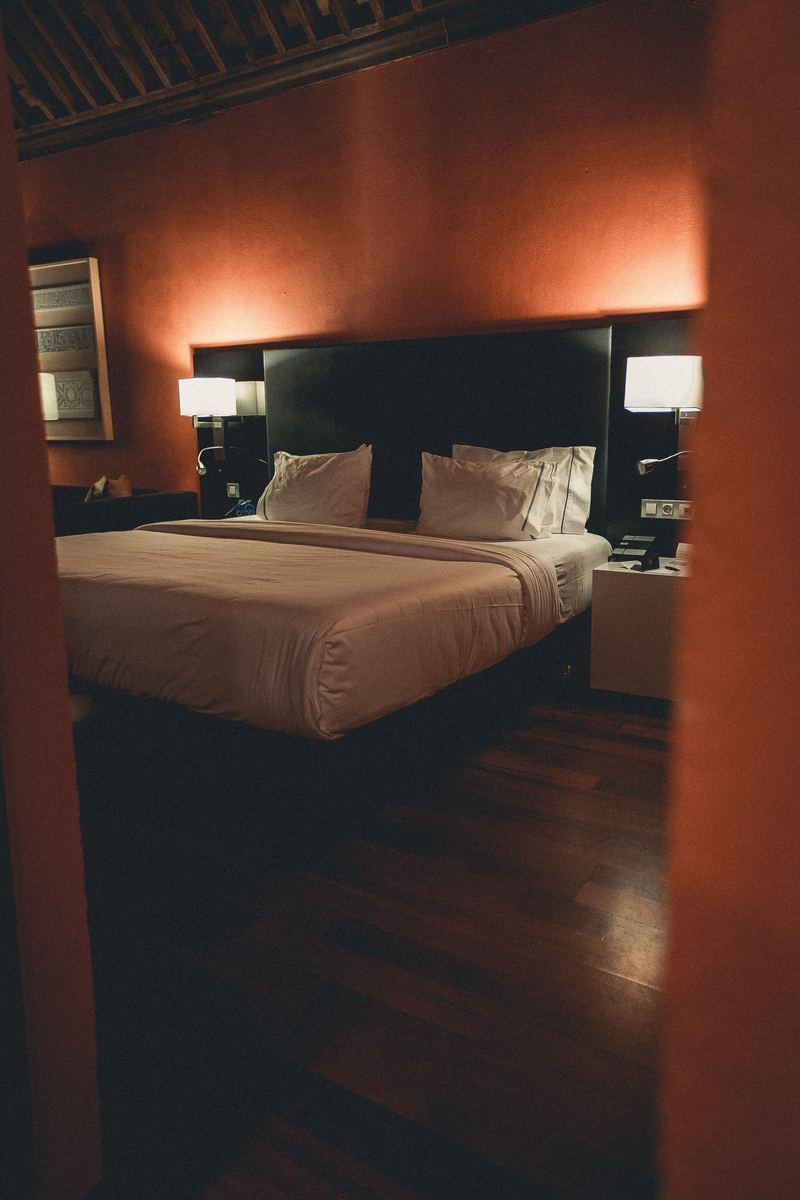 Chambre aux murs terracotta, lit king size et parquet sombre