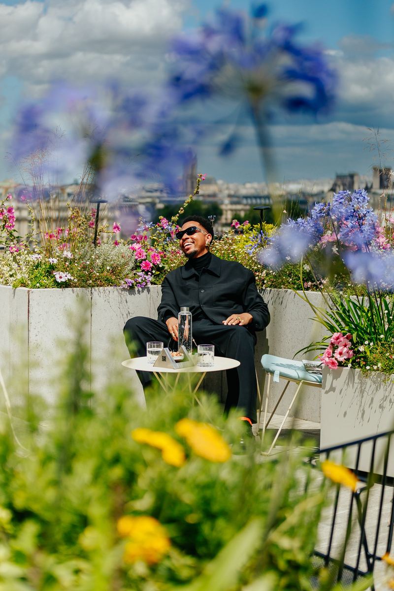 Portrait sur un rooftop fleuri, toits de Paris en arrière-plan
