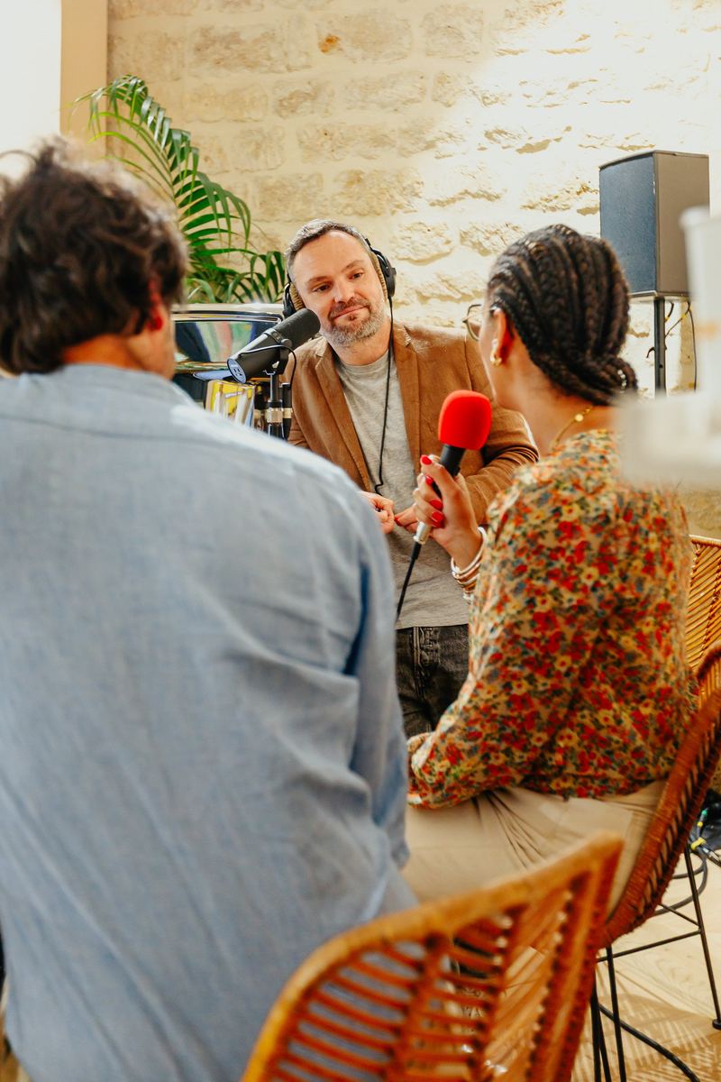 Enregistrement d’un podcast en public, micro rouge à la main