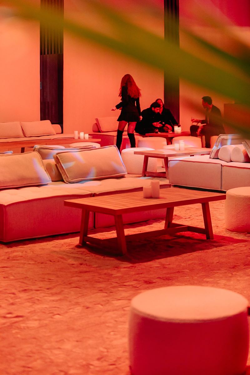 Espace lounge aménagé de canapés, sous un éclairage rouge