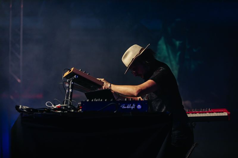 Musicien penché sur ses claviers, chapeau vissé sur la tête