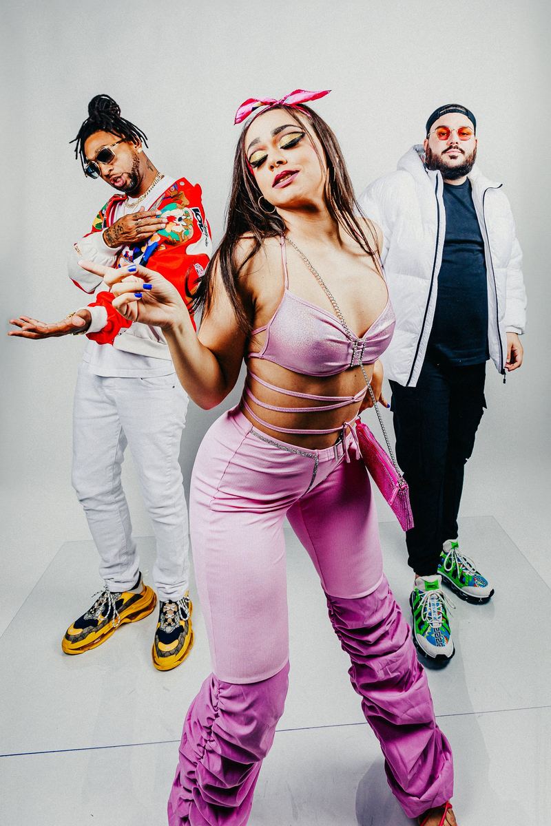 Trio d’artistes pose en studio sur fond blanc, tenues colorées