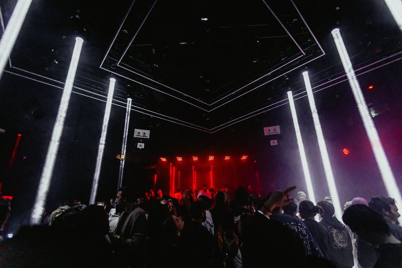 Salle de club rythmée par des tubes lumineux verticaux