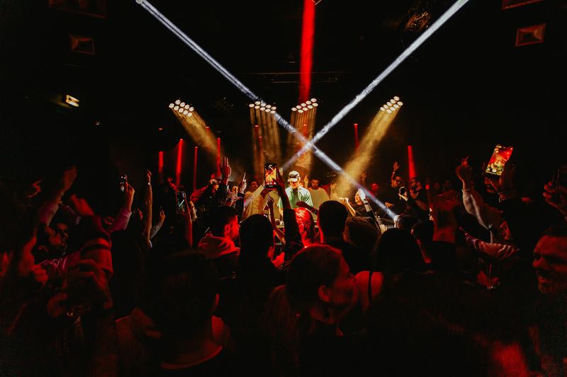 Show sur scène dans un club, faisceaux de lumière au-dessus du public