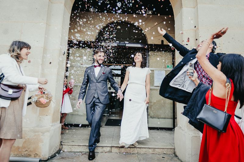 Les mariés sortent de la mairie sous une pluie de confettis