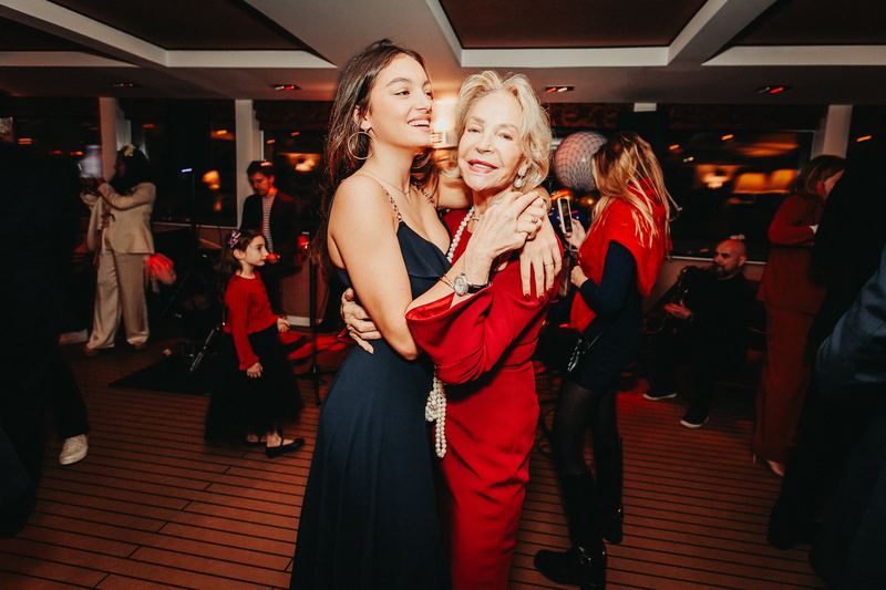 Deux invitées enlacées et souriantes sur la piste de danse