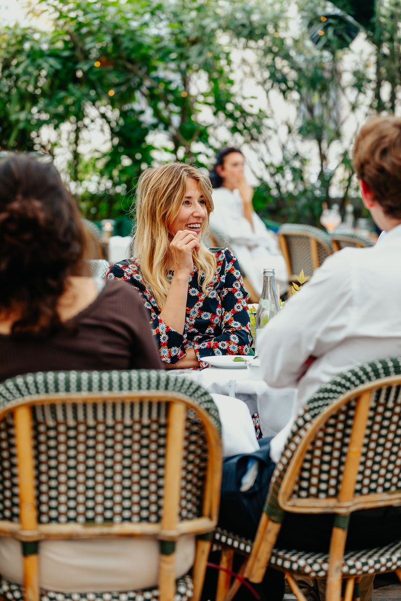 Conversation autour d’une table dressée en terrasse végétalisée