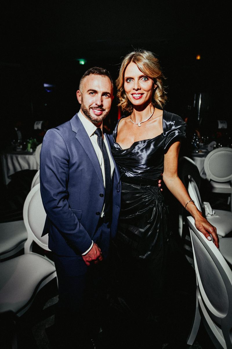 Couple d’invités pose entre les tables du dîner de gala