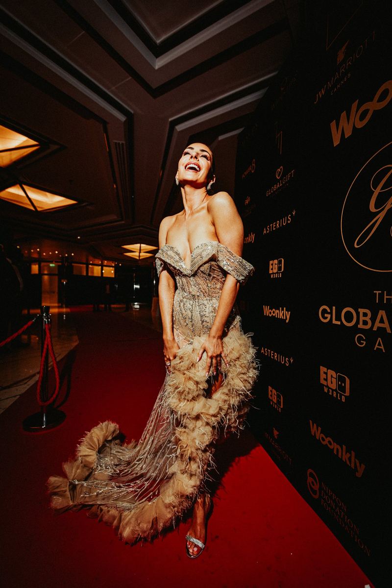 Invitée en robe couture éclate de rire sur le tapis rouge du gala