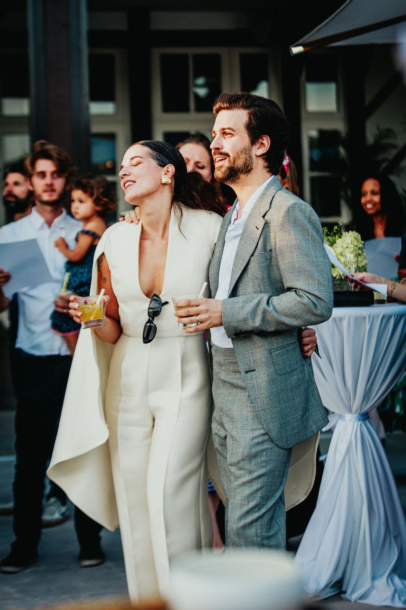 Les mariés rient pendant le cocktail, entourés de leurs invités