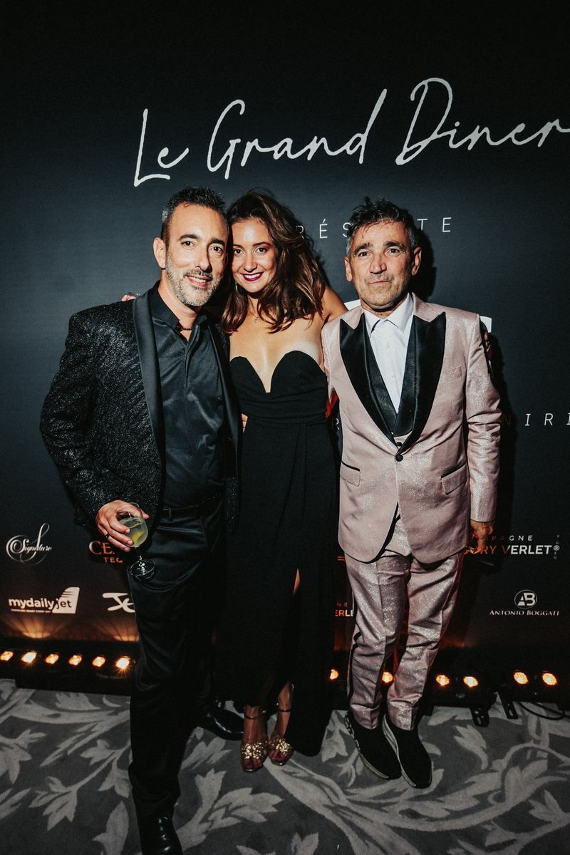Trois invités posent devant le photocall du Grand Dîner