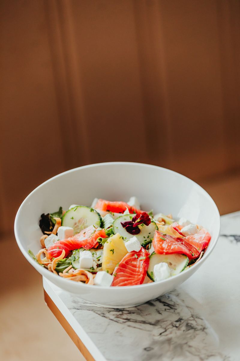 Bol de salade saumon et feta posé sur un plateau de marbre