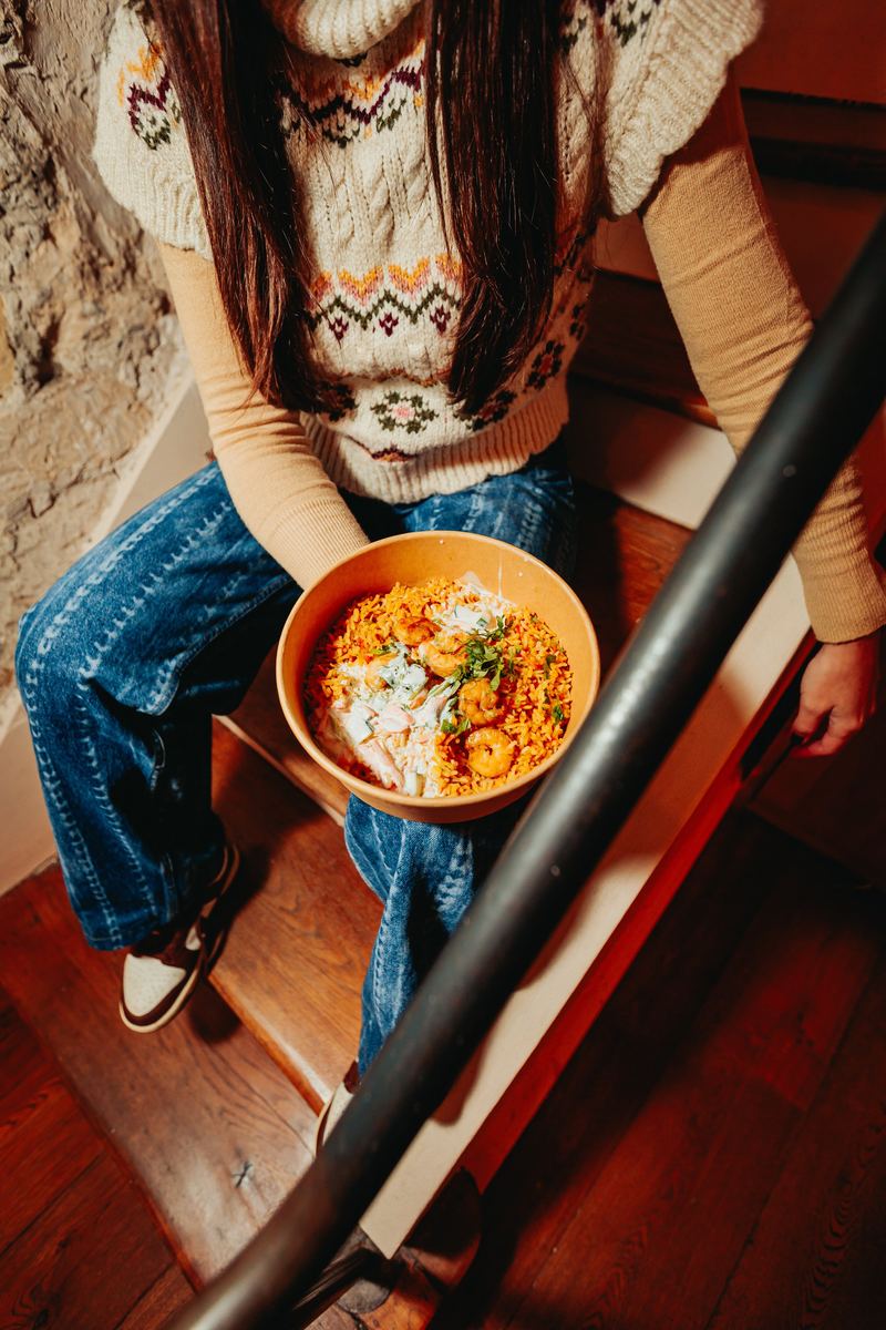 Bol de pâtes photographié en plongée, dans un escalier de bistrot