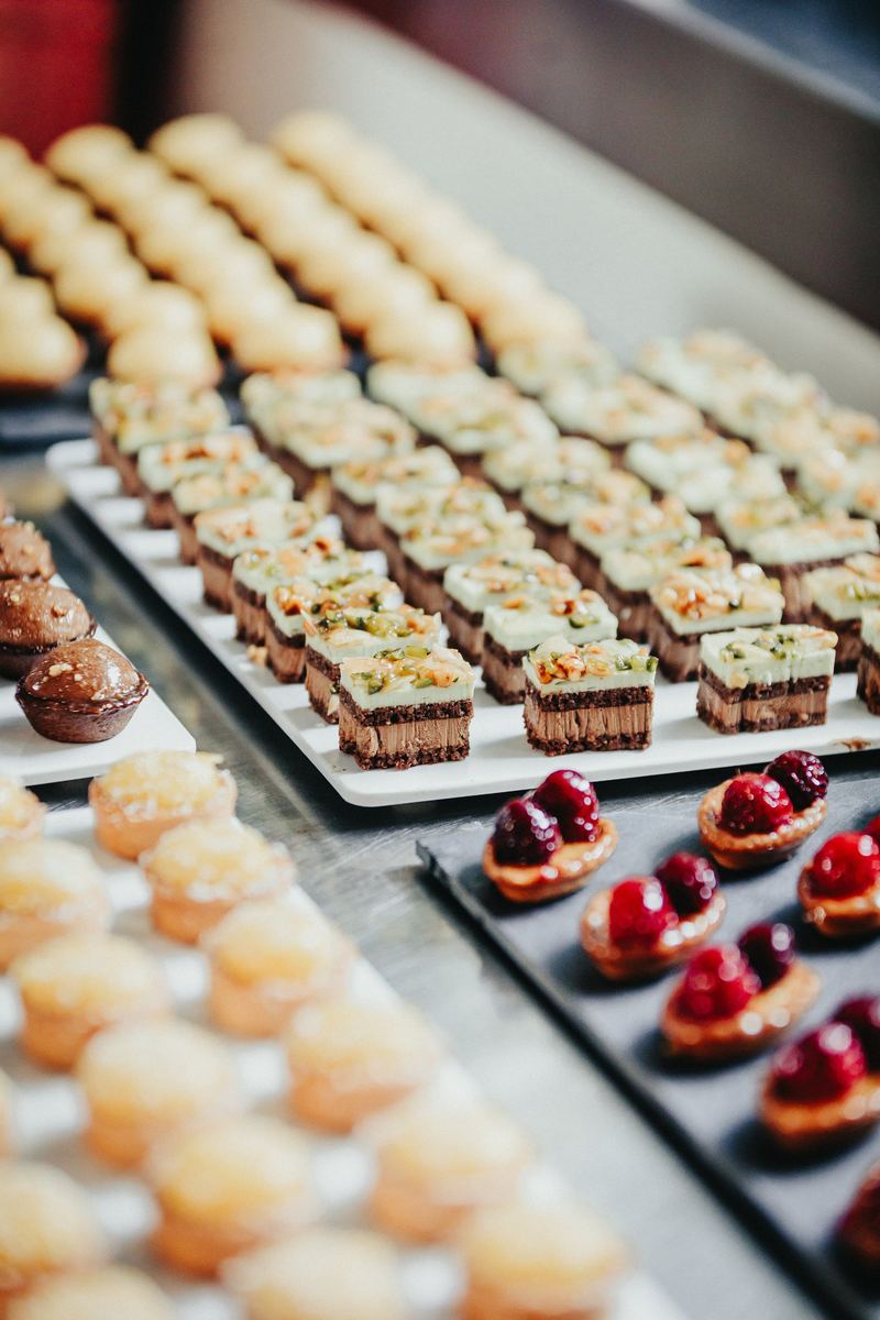 Rangées de petits fours dressés sur plaques, en cuisine