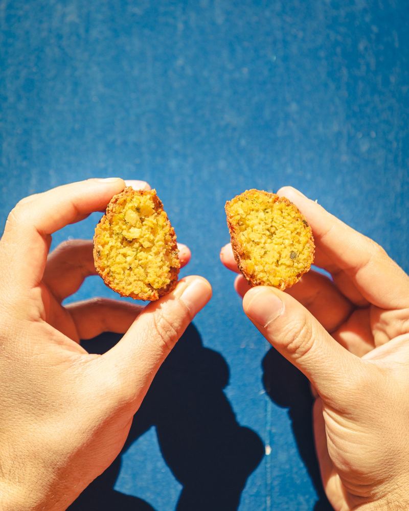 Une convive trempe un toast dans un bol de guacamole
