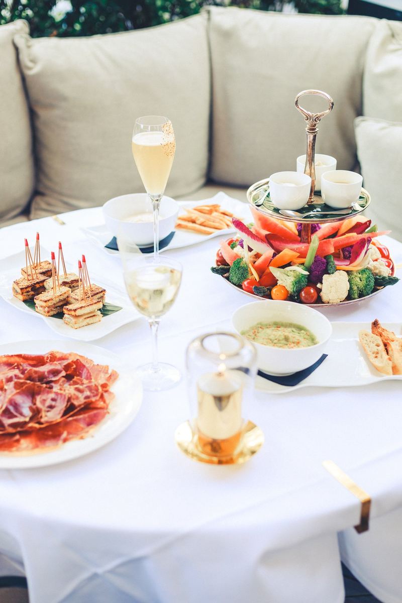 Table de terrasse dressée : charcuterie, crudités, coupe de champagne