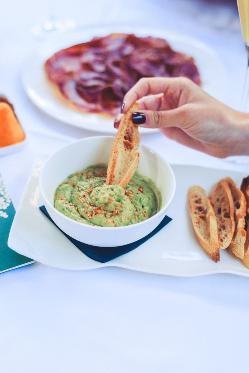 Guacamole et toasts grillés, planche de charcuterie et verre de vin blanc