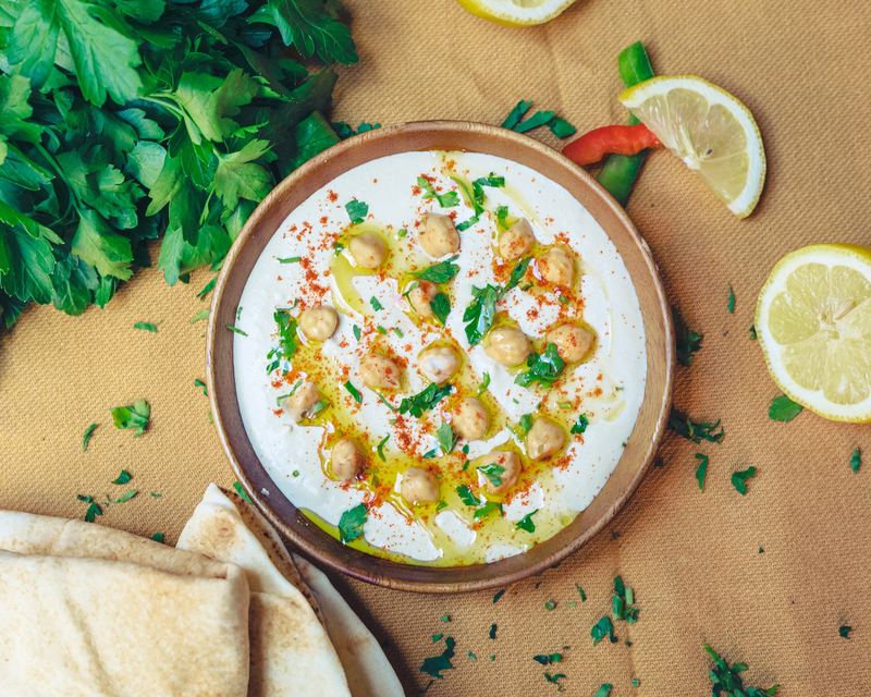Houmous aux pois chiches et paprika, pain pita et citron autour