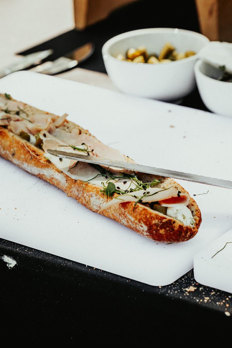 Tartine de baguette au jambon cru et roquette, tranchée au couteau