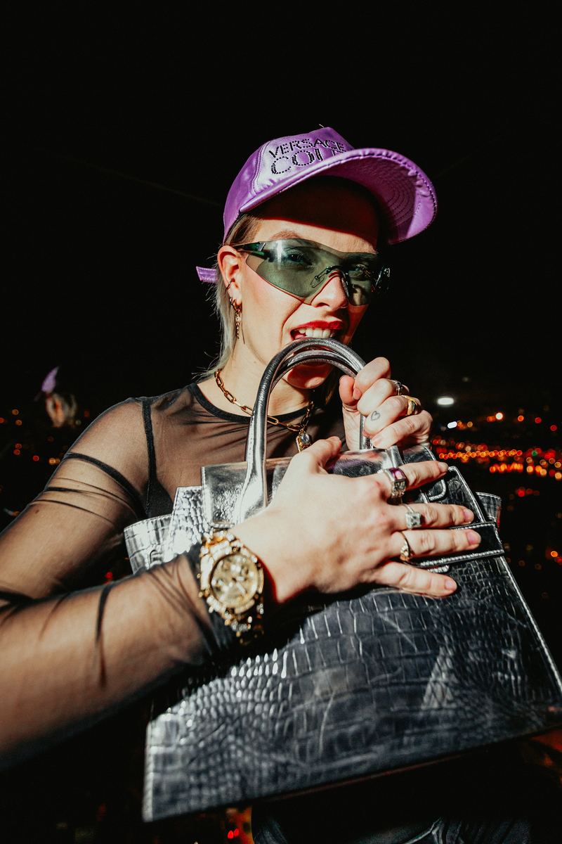 Gros plan sur casquette, lunettes et sac verni, la nuit