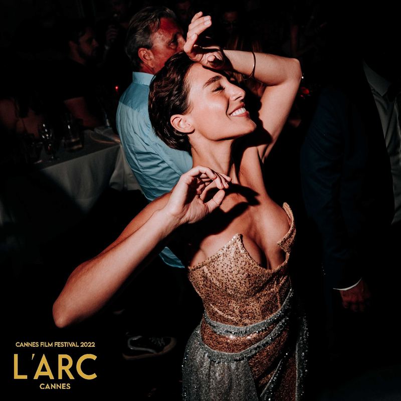 Invitée en robe dorée danse, les yeux fermés