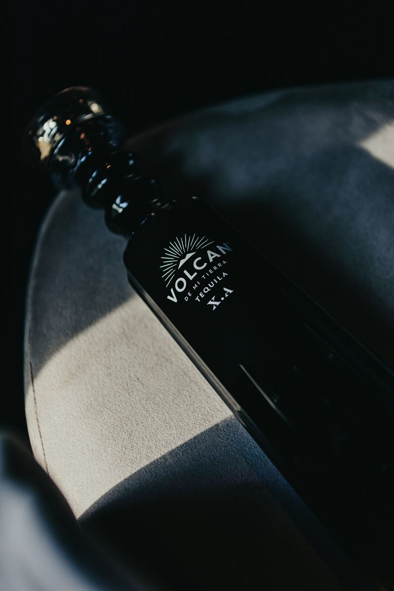 Bouteille de tequila posée sur un tissu graphique noir et blanc