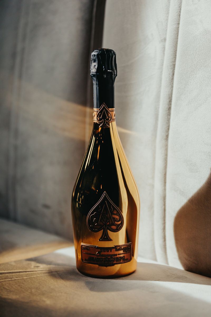 Bouteille de champagne dorée mise en lumière sur un drapé